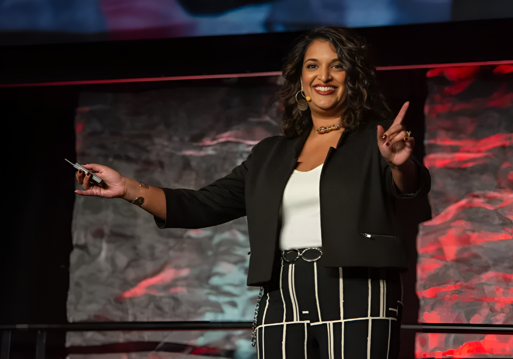 Photo of keynote speaker Tina Varughese presenting on stage at an event.