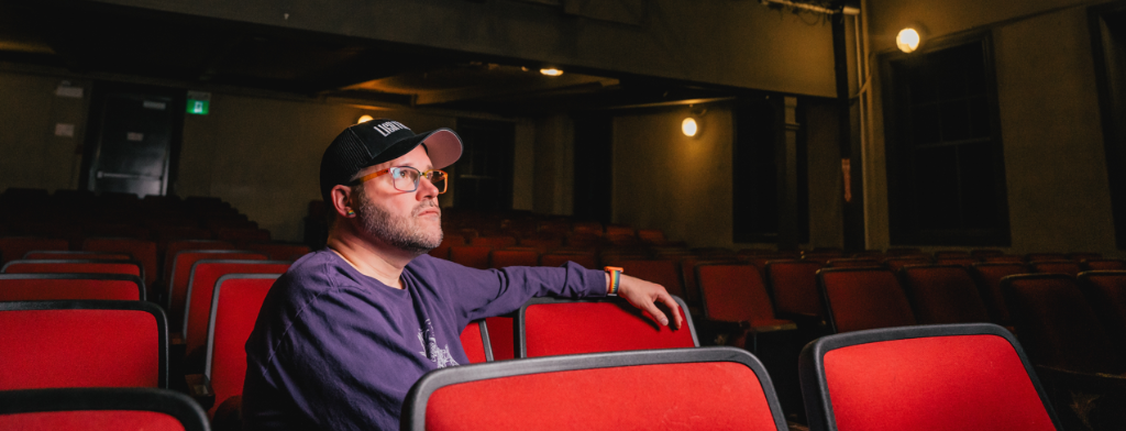 Man sitting inside the Lighthouse Festival Theatre.