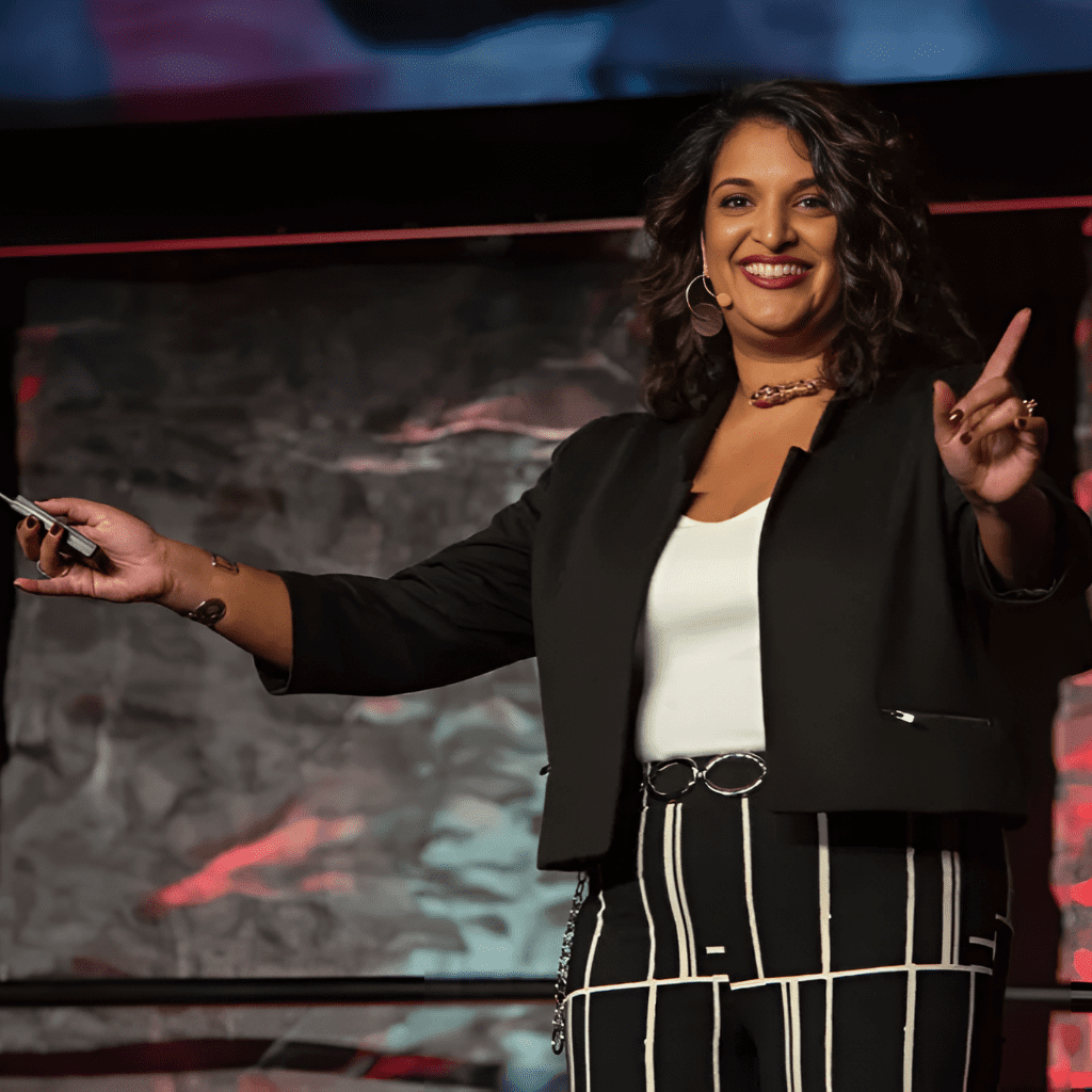 Photo of keynote speaker Tina Varughese presenting on stage.