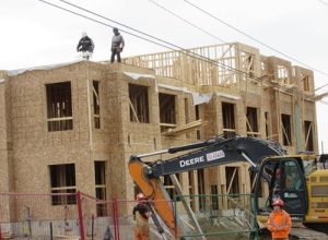 Photo of construction workers building houses